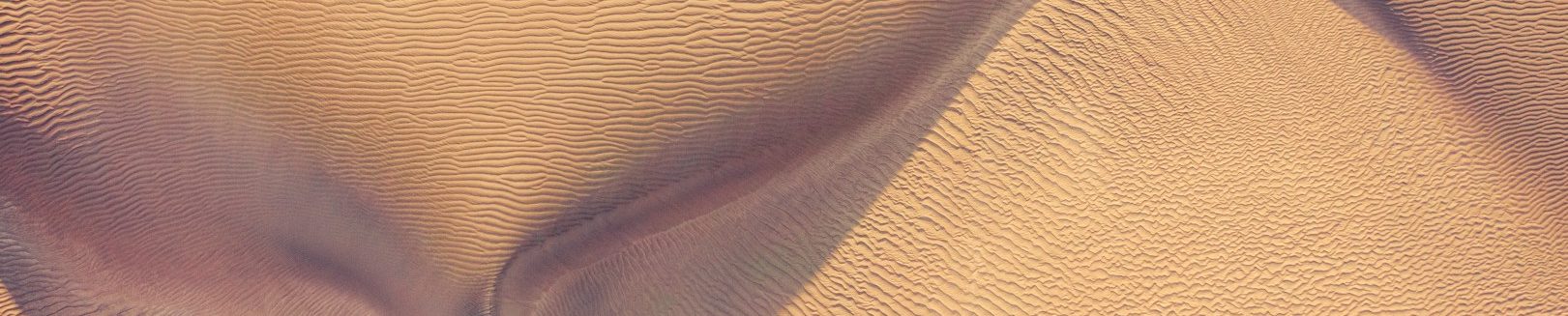 Narbentherapie Bergisch Gladbach Sanfte, geschwungene Formen im Sand, symbolisch für Narben.