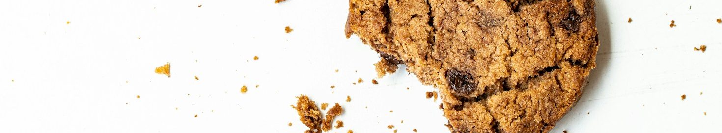 Schokoladenkekse mit einem Biss und Krümeln auf einem hellen Hintergrund, symbolisch für Cookies und DSGVO