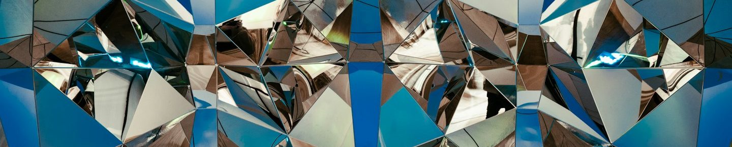 Schmerzmanagement Bergisch Gladbach Bunte, geometrische Muster mit blauen und spiegelnden Flächen, ein Kaleidoskop symbolisch für chronische Schmerzen.