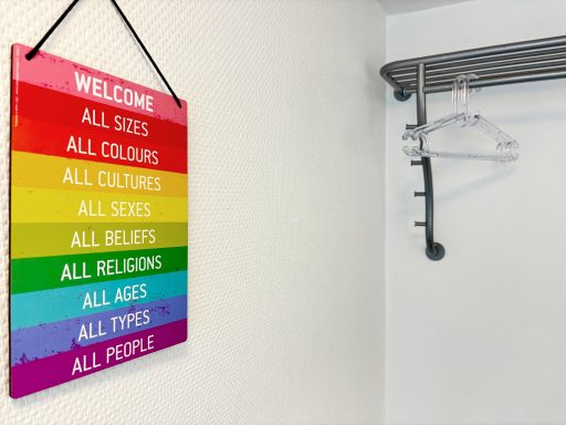 Buntes Willkommensschild mit der Aufschrift „Alle...“ in verschiedenen Farben.